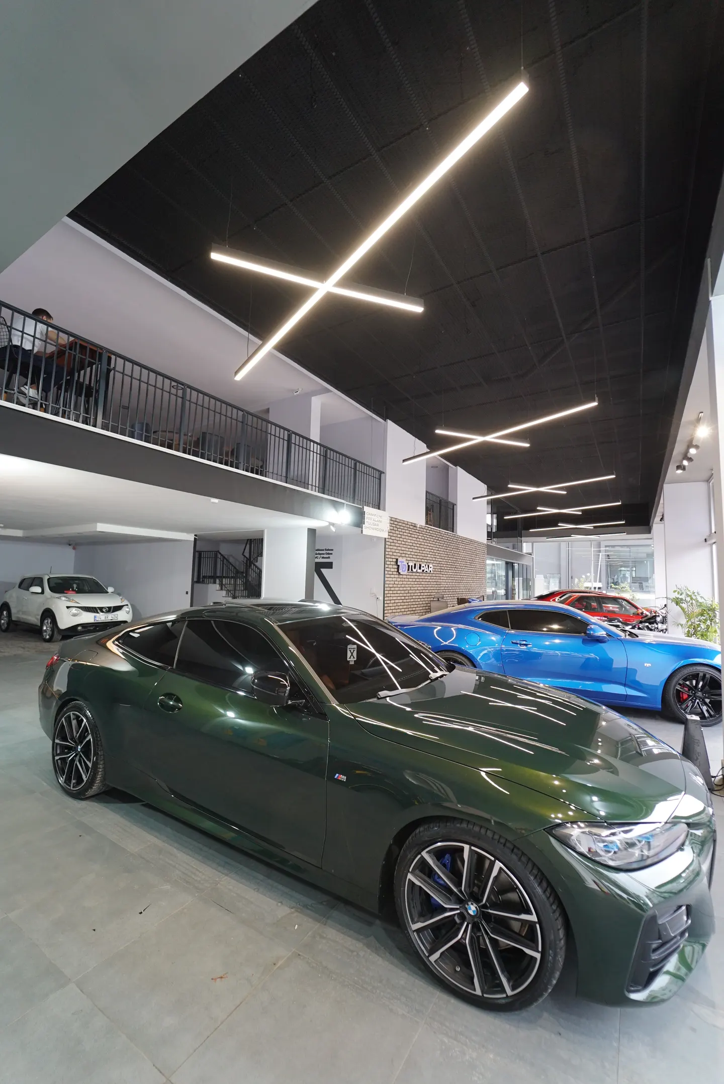Kaplama uygulanmış yeşil BMW showroom aydınlatması altında